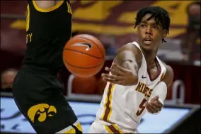  ?? BRUCE KLUCKHOHN - THE ASSOCIATED PRESS . ?? Minnesota guard Marcus Carr passes the ball around Iowa guard Joe Wieskamp, left, during the second half of an NCAA college basketball game Friday, Dec. 25, 2020, in Minneapoli­s. Minnesota won 102-95in overtime.