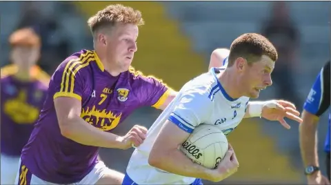  ??  ?? Wexford’s Tiarnan Rossiter tries to halt the run of Michael Curry (Waterford).