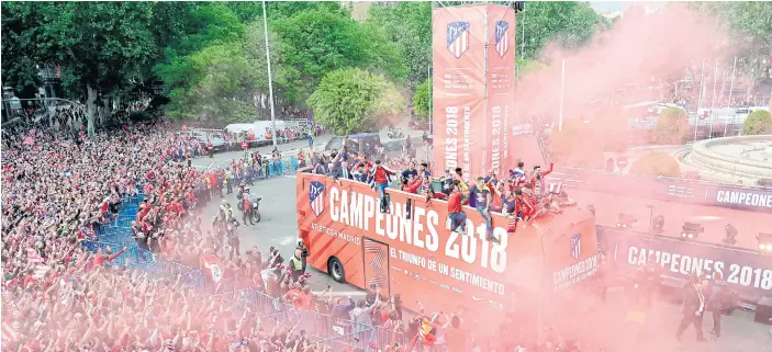  ??  ?? Atletico players on an open-top bus celebrate their Europa League victory with fans in Madrid on Friday.