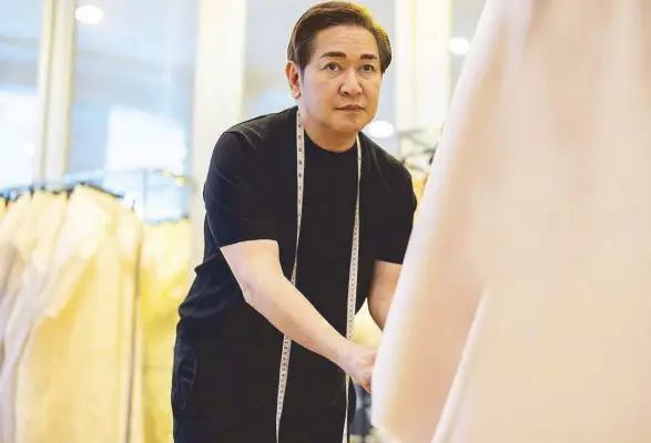  ?? ?? Master designer Paul Cabral at work: He envisions clothes that are so timeless, women will still want to wear them 10 years from now. But “a modern flair is needed for our Filipinian­a.” He hopes the piña can be developed into something sturdier and more manageable.