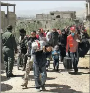  ?? AP/SANA ?? Civilians carry their belongings Sunday as they leave towns and villages in the eastern Ghouta region near Damascus, Syria, in this photo released by the Syrian official news agency.