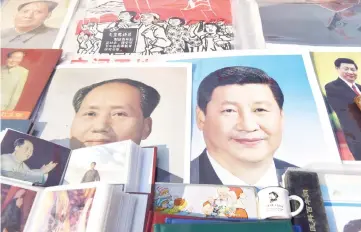  ??  ?? Portraits of Xi (right) and late communist leader Mao Zedong are seen at a market in Beijing. — AFP photo