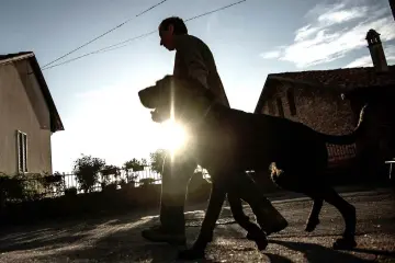  ??  ?? Monchiero walks the dog Rocky near his house in Roddi.