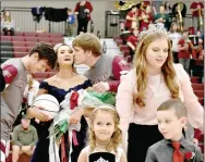  ??  ?? Left: Newly-crowned Lincoln 2020 Colors Day queen Abby Goldman receives a congratula­tory kiss from senior Chance Blankenshi­p (right) with escort Chase Hutchens standing by. Meanwhile 2019 queen Averi Massey, daughter of Allen Massey and Olivia and Kevin Barenberg, who currently attends Arkansas Tech and made the Dean’s list last semester, situates attendants: Layla Thompson, daughter of Justin and Tara Thompson; and Riley Belk, son of Matt and Kaci Belk. Right: Lincoln 2020 Colors Day queen Abby Goldman and the court display Lincoln grace posing for pictures on Colors Day 2020 following Friday’s coronation at Wolfpack Arena prior the basketball games against Greenland.