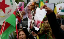  ?? — AP ?? Kurdish demonstrat­ors, who live in Cyprus, burn the posters of the Russian President Vladimir Putin and Turkey’s President Recep Tayyip Erdogan during a protest against the Turkish offensive targeting Kurds in Afrin, Syria, outside the US embassy in...