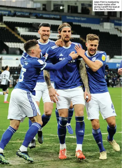  ??  ?? Aden Flint is mobbed by his team-mates after giving Cardiff the lead at the Liberty Stadium