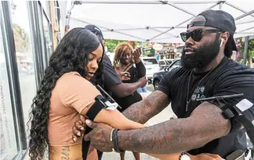  ?? ?? Joshua chisolm (right) of True breed executive Protection teaching andrea Johnson to use a tourniquet after a nearby shooting killed three and wounded 11 people. — TNS