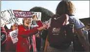  ?? Arkansas Democrat-Gazette/THOMAS METTHE ?? Elaine Landrum (center) of Maumelle pats UALR’s Kiara Scott on the shoulder during the Lady Trojans’ send-off Thursday at the Jack Stephens Center in Little Rock. Landrum says she has been a UALR fan for 37 years.