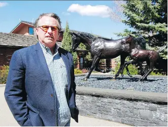  ?? DEAN PILLING ?? Shawn Hansen, with Hansen Land Brokers, is handling the auction for Clay Riddell’s home, behind him. The 11,500-square-foot home in the Red Deer Lake area has a horse stable and indoor pool.