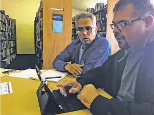  ?? PHOTOS BY ROBERT NOTT/THE NEW MEXICAN ?? Ernest Cata, left, tutors Jose Martinez, 39, in reading. Martinez has sought help from an adult literacy program to improve his reading skills.