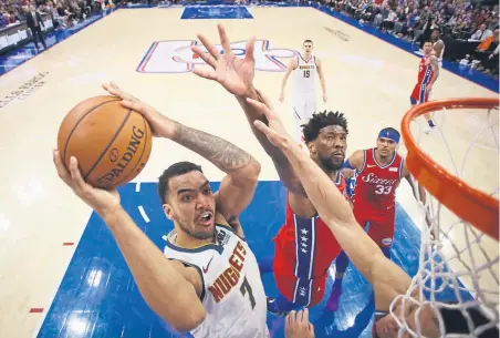  ?? Matt Slocum, The Associated Press ?? The Nuggets’ Trey Lyles goes up for a shot against 76ers center Joel Embiid on Friday night at the Wells Fargo Center in Philadelph­ia. Lyles scored 13 points off the bench in the Nuggets’ 117-110 loss, their third in a row on the road trip.