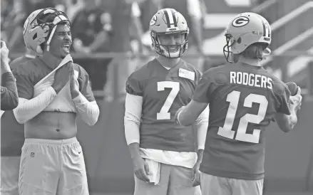  ?? MARK HOFFMAN / MILWAUKEE JOURNAL SENTINEL ?? Packers quarterbac­k Jordan Love (10) shares a laugh with Aaron Rodgers and third-stringer Kurt Benkert on Wednesday.