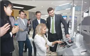  ??  ?? Customers from the Bank of Russia visit GRG Banking Equipment Co Ltd in March.