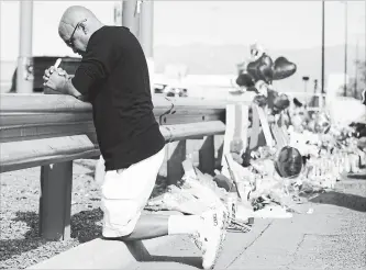  ?? MARIO TAMA GETTY IMAGES ?? Angel Gonzalez prays next to a makeshift memorial near the scene of a mass shooting in El Paso, Texas, on Saturday that left at least 22 people dead. A 21-year-old male suspect was arrested.