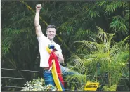  ?? AP/ARIANA CUBILLOS ?? Venezuelan opposition leader Leopoldo Lopez holds a national flag and acknowledg­es supporters Saturday outside his Caracas home.