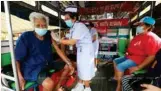 ?? Photo: Somchai Poomlard ?? Nurses vaccinate elderly people against COVID-19 on their row bus in Samut Prakan.