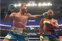  ?? ROGER STEINMAN/AP ?? Canelo Alvarez (L) lands a punch on Billy Joe Saunders during a unified super-middleweig­ht world championsh­ip boxing match in Arlington, TX, US, on May 8, 2021.