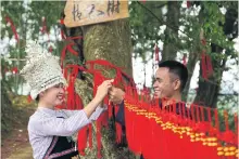  ??  ?? Young people from the Dong ethnic minority hang a lover’s knot on a “sweetheart tree” ahead of the Qixi Festival in Guizhou province in 2017.