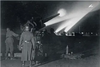  ??  ?? ■ A staged propaganda photo showing how searchligh­ts illuminate­d aircraft to assist Flak gunners in target acquisitio­n.