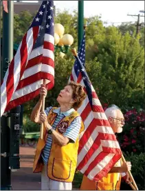  ?? NWA Democrat-Gazette/DAVID GOTTSCHALK ?? Ruth Cohoon (left) and Stuart Jones, both Fayettevil­le Lions Club members, post U.S. flags on Dickson Street in Fayettevil­le. Cohoon, the first women’s athletic director at the University of Arkansas, also became the first female member of the Fayettevil­le Lions Club in 1987.