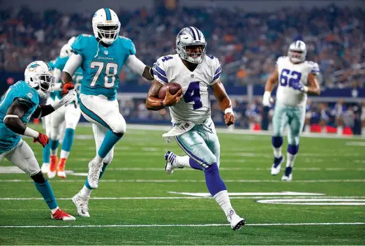  ?? Associated Press ?? Miami Dolphins’ Terrence Fede gives chase as Dallas Cowboys quarterbac­k Dak Prescott heads to the end zone for a touchdown during the first half Friday in Arlington, Texas. After Tony Romo broke a bone in his back on the third play of the third...