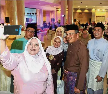  ??  ?? Many fans: Raus obliging staffers with a group selfie at the Raya celebratio­n at the Palace of Justice in Putrajaya. — Bernama