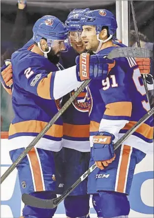  ?? GETTY ?? Josh Bailey (c.) celebrates with teammates Nick Leddy (l.) and John Tavares after scoring the game-winner against the Flyers in overtime Wednesday.