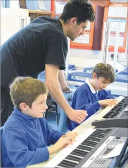  ?? FM4723392 ?? David Walthow, of Livewire Rock Academy, helps Harry and George on keyboards