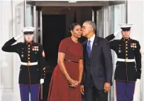  ?? Kevin Dietsch / Getty Images ?? Barack Obama gives Michelle Obama a kiss at the White House as they await Donald Trump at the inaugurati­on.