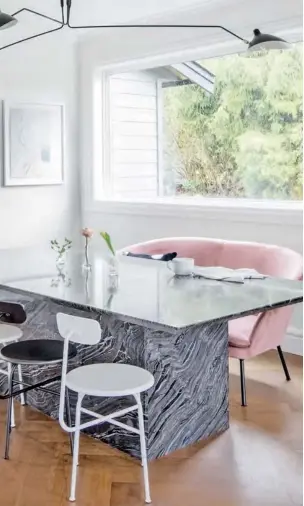  ?? DINING CHAIRS, Vancouver Special; CHANDELIER, Stilnovo. ?? LEFT The heavy look of the marble dining table is balanced by the lanky lightness of the chairs and Serge Mouille-style chandelier.