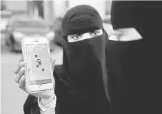  ??  ?? A Saudi woman shows the Careem app on her mobile phone in Riyadh, Saudi Arabia. Saudi Arabia hopes its plan to bring a further 1.3 million women into the workforce by 2030 will be given a lift from ride-hailing apps Uber and Dubai-based rival Careem. —...