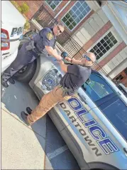  ?? Contribute­d ?? Cedartown Police Chief Jamie Newsome (left) helps tie a teal ribbon onto one of the department’s patrol cars in honor of sexual assault survivors on Monday, April 12.