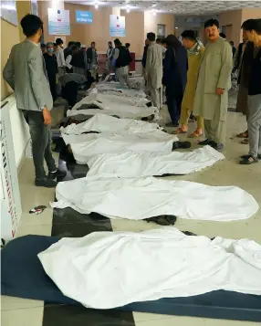  ?? Photo: AP ?? Men try to identify bodies at a hospital after bomb blasts that targeted a girls’ school near Kabul.