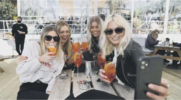  ??  ?? 0 A group of friends enjoy a drink in Manchester as England takes another step back towards normality with the further easing of lockdown restrictio­ns