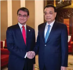  ??  ?? Taro Kono (left) shakes hands with Li Keqiang at Zhongnanha­i in Beijing. — Reuters photo