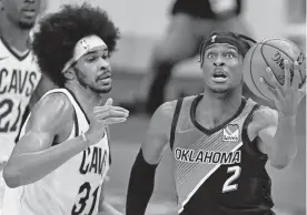  ??  ?? Thunder guard Shai Gilgeous-Alexander (2) drives to the basket against Cavaliers center Jarrett Allen (31) in the second half of OKC's 117-101 win Sunday night in Cleveland. [AP PHOTO/ TONY DEJAK]