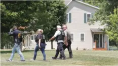  ?? JEFF ROBERSON/ AP ?? Law enforcemen­t officials investigat­e outside the Belleville, Illinois, home of James T. Hodgkinson on Wednesday.