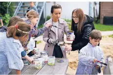 ??  ?? Ardita Thaqi und Carina Barth (v. l.) halfen mit beim Ölen der Bänke im Schulgarte­n der Adolf-Clarenbach-Grundschul­e in Isenbügel.