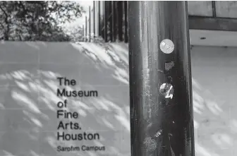  ?? Marie D. De Jesús / Staff photograph­er ?? Museum of Fine Arts, Houston admission stickers were left on a pole at the museum on Bissonnet. Because of this and other defacement, the museum will opt to use recyclable tags.