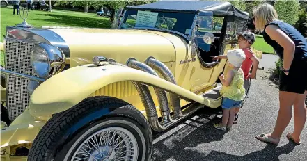  ??  ?? Rachel Quertier with James, 4, and Sophie, 2, look over the 1969 SS Excalibur Phaeton.