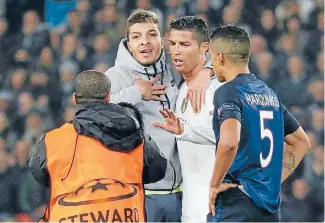  ?? Photo: REUTERS ?? A plucky pitch invader makes it all the way to his football hero, Real Madrid’s Cristiano Ronaldo, for a hug during what was an otherwise dull scoreless Champions League draw between Madrid and Paris Saint-Germain at the Parc des Princes in Paris...