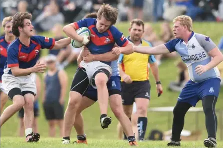  ?? PETER LEE, RECORD STAFF ?? Waterloo Collegiate Institute Vikings ball carrier Josh Rosenblum, centre, is tackled by an unidentifi­ed SJAM Highlander­s player, obstructed from view, and Hayden Litwiller, right. Vikings’ Chris Gadbois, left, moves in on the play. WCI won the...