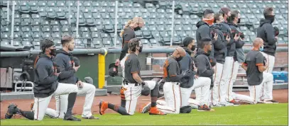 ?? Jeff Chiu The Associated Press ?? Giants players and coaches kneel during the national anthem before an exhibition game Tuesday against the Athletics.