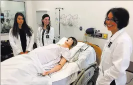  ?? Sean Whaley ?? Las Vegas Review-journal Dr. Neda Etezadi-amoli, right, explains using a pregnant mannequin to Alexandra Magliardit­i, left, and Melissa Kelley at the University of Nevada, Reno Medical School.