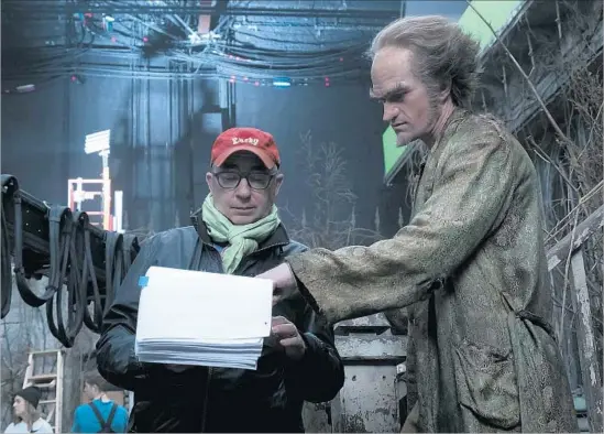  ?? Joe Lederer Netf lix ?? DIRECTOR BARRY SONNENFELD, left, checks the Lemony Snicket script with Neil Patrick Harris on the set of Netflix’s “A Series of Unfortunat­e Events.”