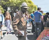  ?? Grace Li / The Chronicle ?? Horace Thomas looks for a buttonmaki­ng machine so he can add to his collection at the 20th Street Block Party.