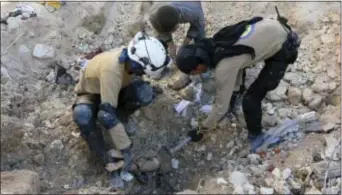  ?? SYRIAN CIVIL DEFENSE WHITE HELMETS VIA AP ?? In this photo provided by the Syrian Civil Defense group known as the White Helmets, shows members of Civil Defense removing a dead body from under the rubble after airstrikes hit in Aleppo, Syria, Saturday. Syrian government forces captured a...