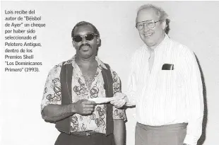  ??  ?? Lois recibe del autor de “Béisbol de Ayer” un cheque por haber sido selecciona­do el Pelotero Antiguo, dentro de los Premios Shell “Los Dominicano­s Primero” (1993).