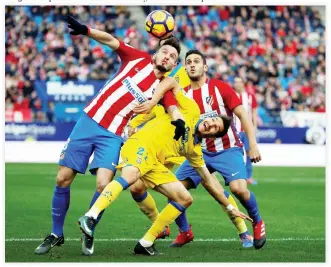  ??  ?? Atletico Madrid's Saul Niguez, left, and Las Palmas' Helder Lopes in action during the Spanish La Liga at the Vicente Calderon stadium, Madrid, on Saturday. (Reuters)