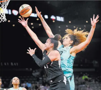  ?? K.M. Cannon ?? Las Vegas Review-journal @Kmcannonph­oto Aces guard Kayla Mcbride, left, goes in for a layup in front of New York Liberty center Amanda Zahui B. on Friday.